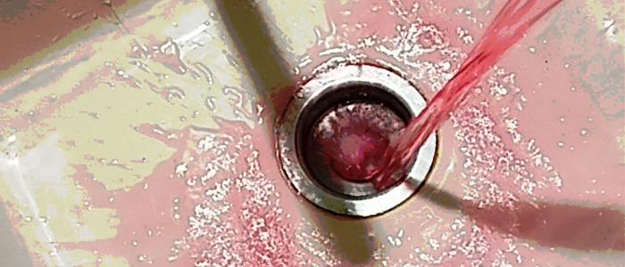 Liquid being poured down drain